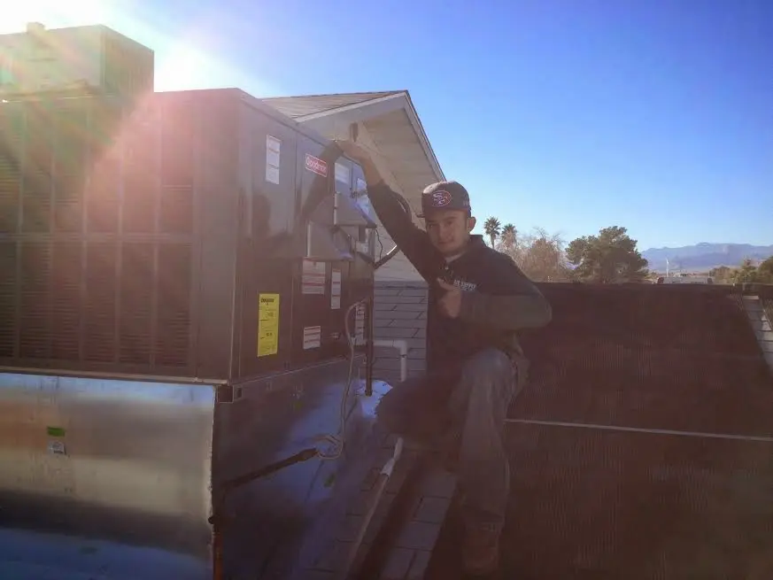 HVAC technician performing AC Tune-Up on a rooftop unit in St. Louis Park